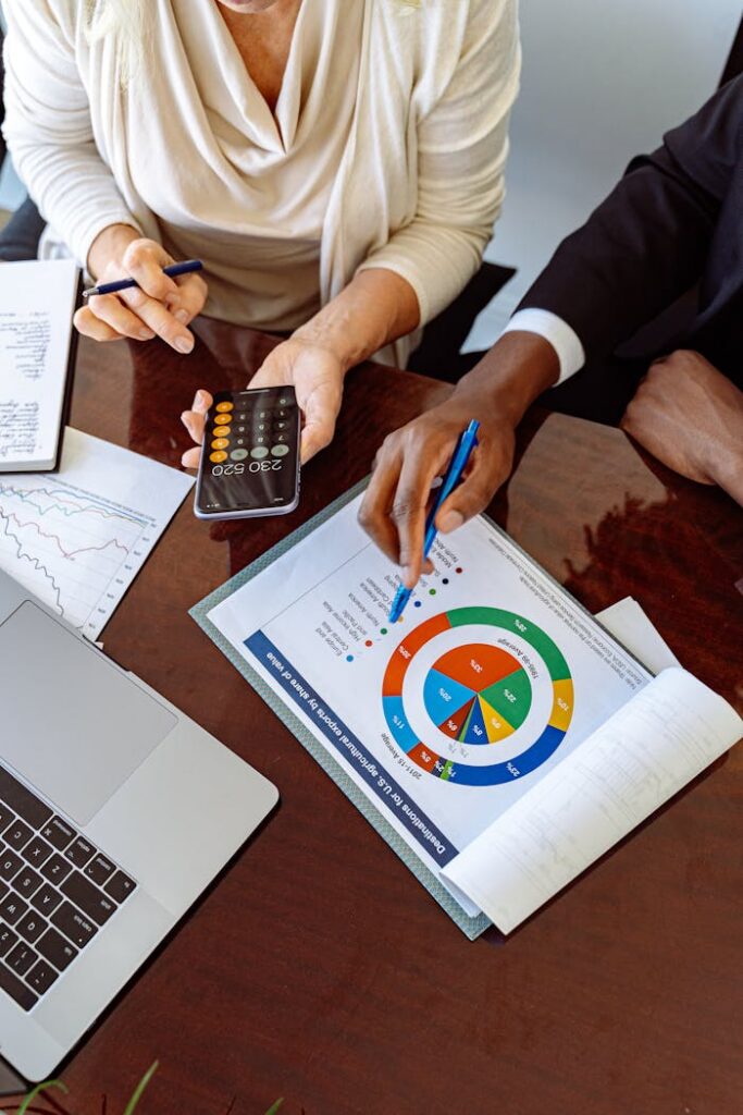 Mines Two business professionals discussing financial documents and strategies at an office desk.