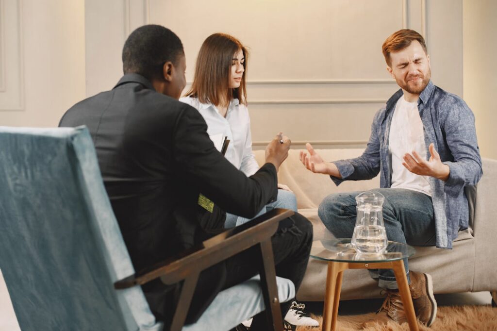 Actualités A diverse couple in a serious conversation with a lawyer during a meeting in an office setting.